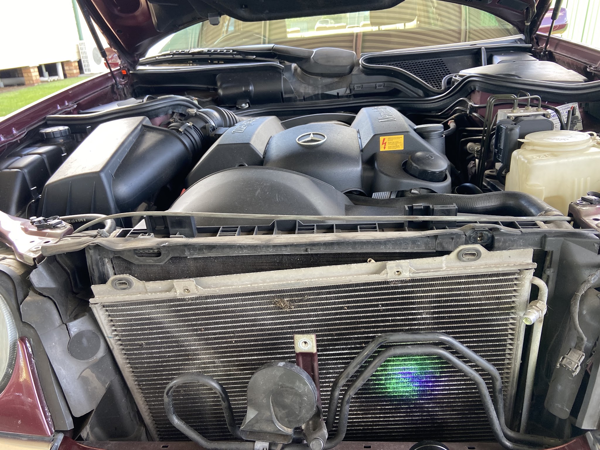 Mercedes-Benz engine bay with the front bar removed and the air-conditioning condenser exposed
