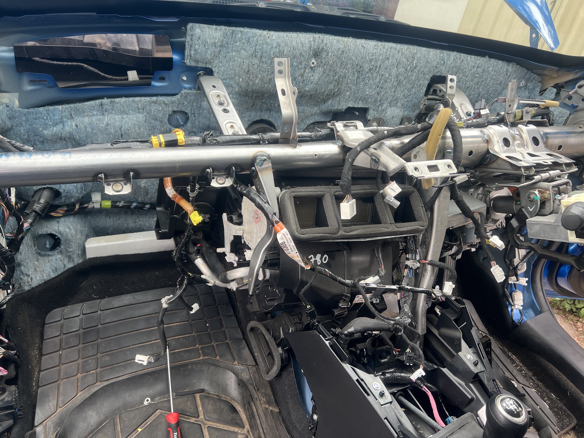 A car with the entire dashboard removed down to the crossmember to reach the heater and air-conditioning box