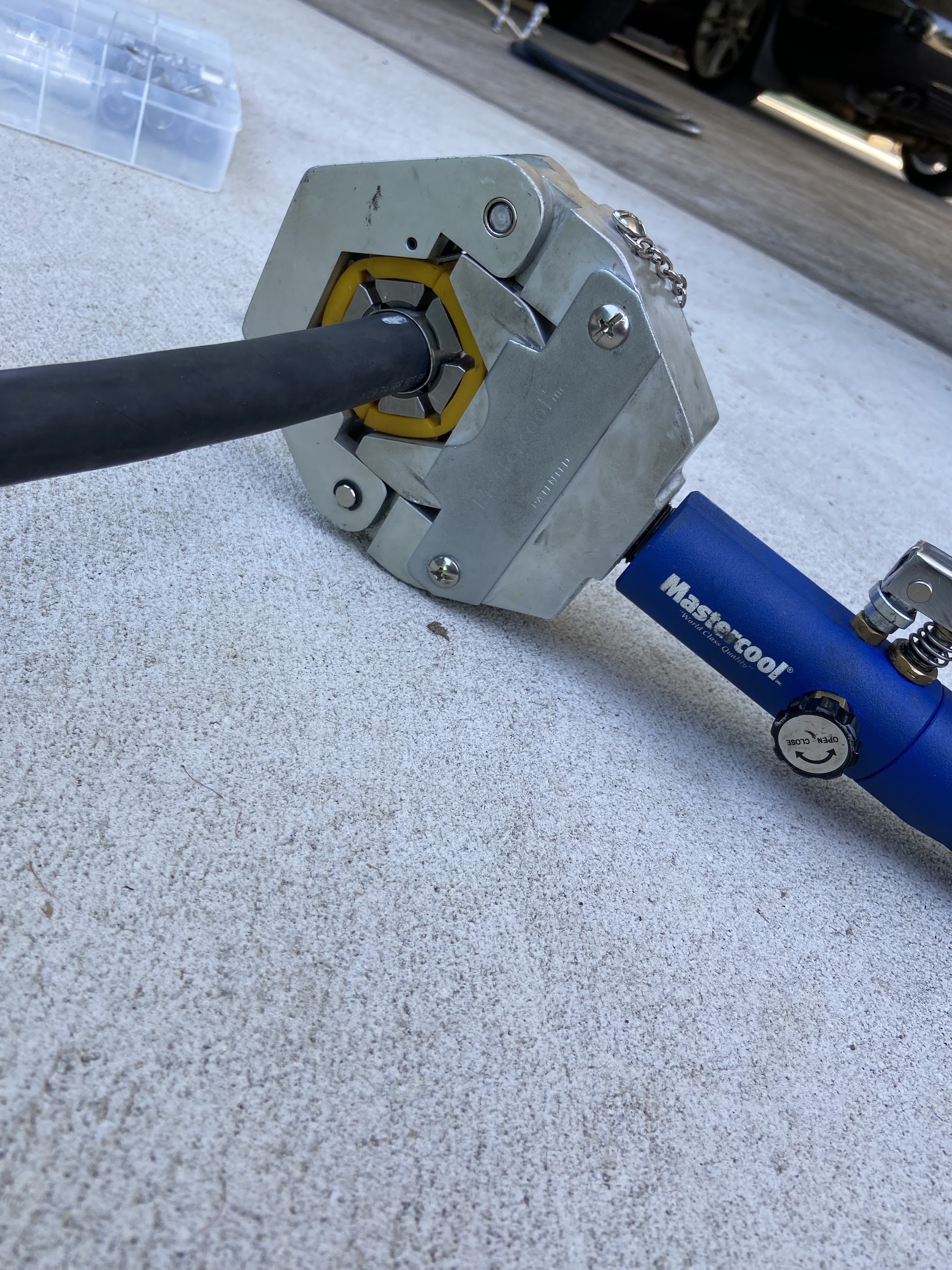 Hydraulic hose crimping tool closed onto an air-conditioning hose